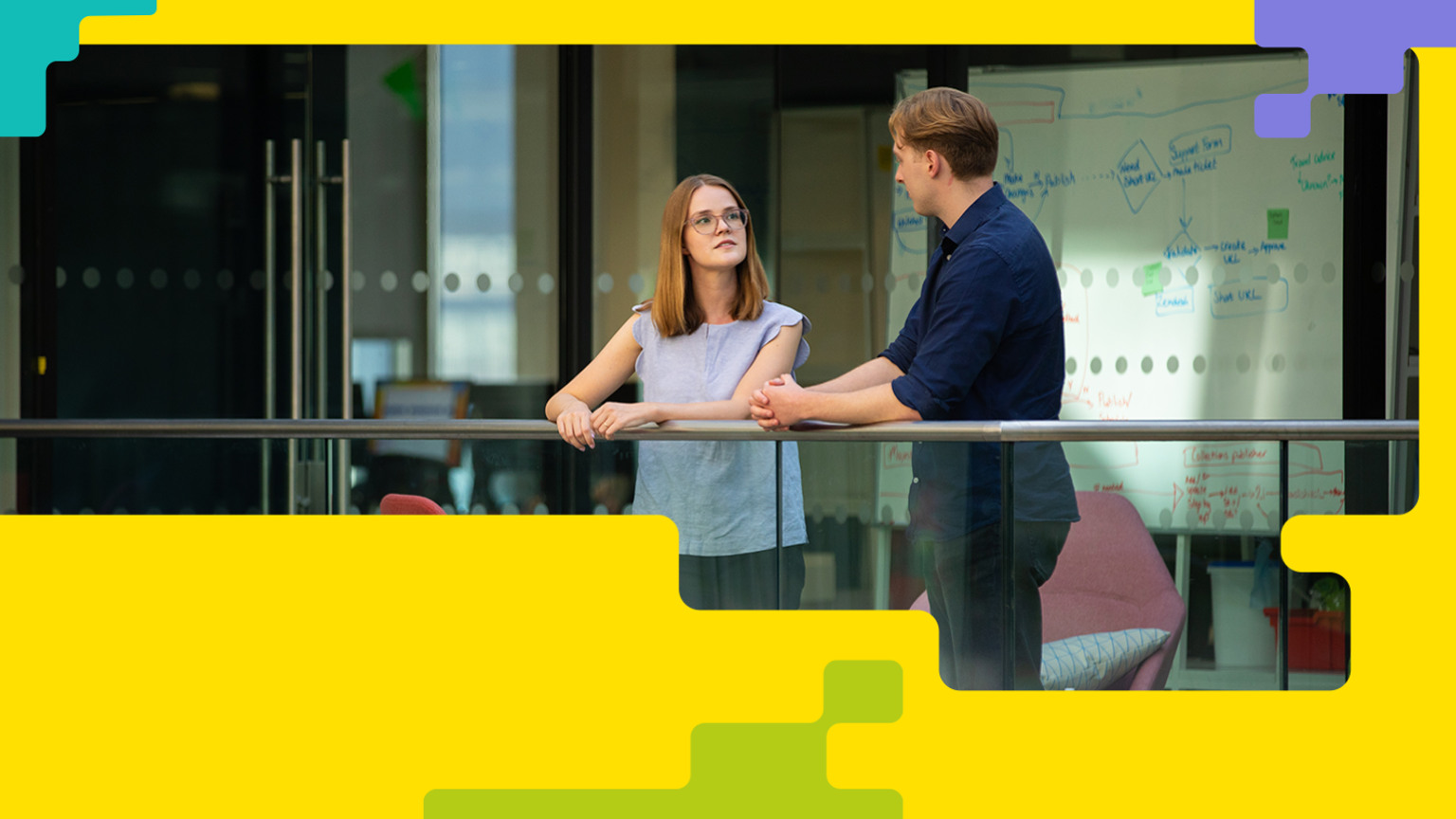 A man and a woman stand and converse near a railing in a modern office space, with a whiteboard covered in notes and diagrams in the background. The scene is framed by colourful geometric shapes, suggesting a collaborative and professional environment.